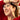 Woman wearing red earrings with a blurred background