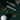 Gold necklace with charms, golf ball, and tees on a dark green surface