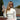Woman holding a paddle on a tennis court with sunglasses on her head